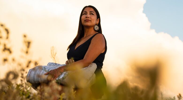 A woman standing in a field is pictured.