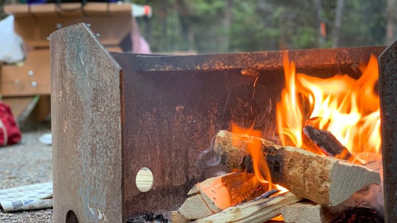 A fire pit is seen with orange flames.