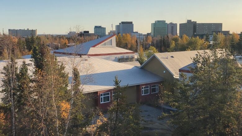 Buildings seen amid trees.