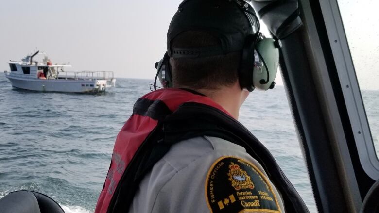 A DFO officer monitors a commercial fishing vessel during an enforcement operation in Boundary Bay, Sept., 2020.