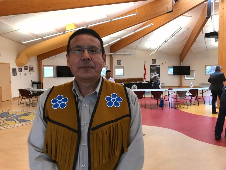 A portrait of a man in a beaded vest.