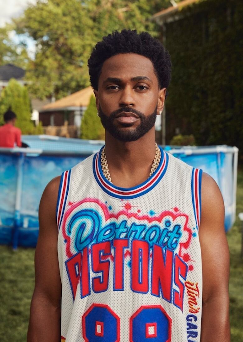 Man standing in Detroit Pistons shirt.