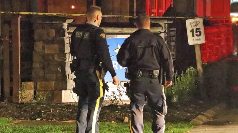 Two police officers are seen from behind.