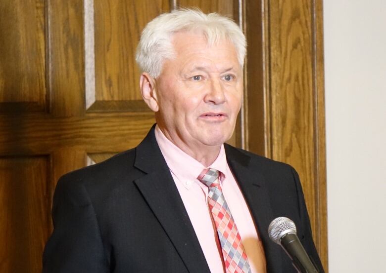 A man in a suit with grey hair.