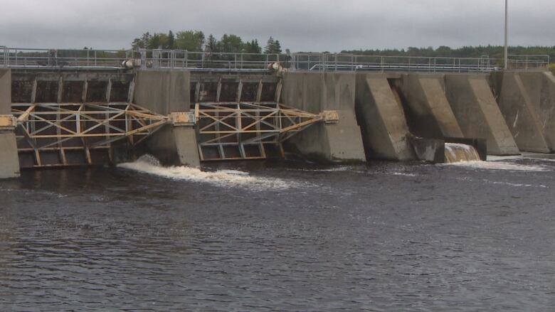 A concrete dam over water.