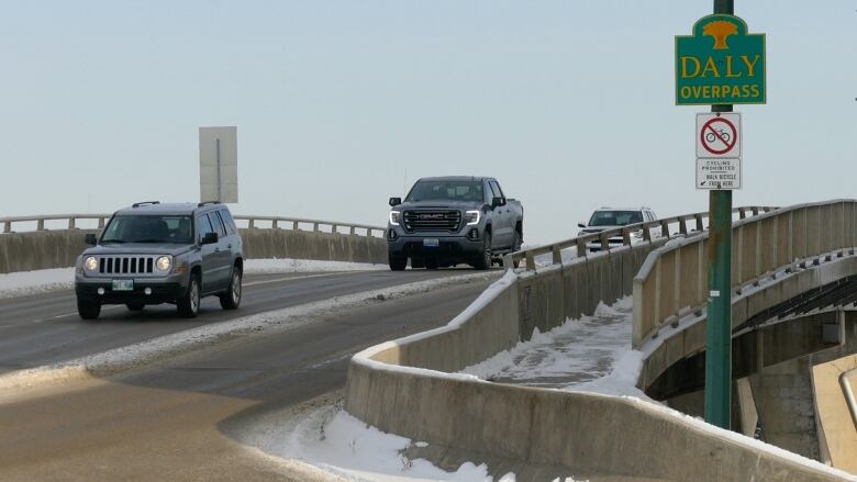 A view of an overpass as trucks drive down it. 