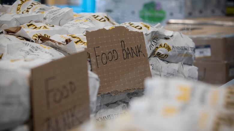 A close up shot of food wrapped on a table. Small cardboard signs in front of it say 