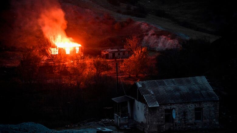 A house burns in a village outside the town of Kalbajar after a peace agreement was signed to end the military conflict between Armenia and Azerbaijan over the disputed Nagorno-Karabakh region.