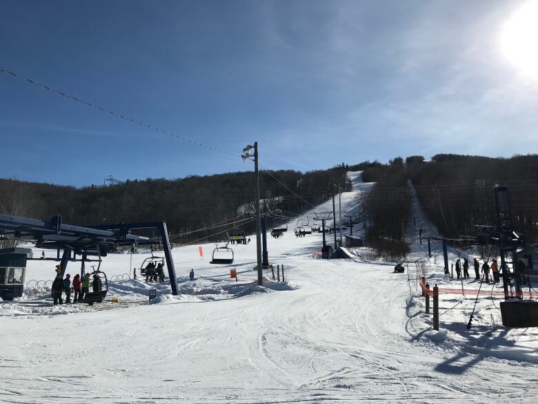 A chairlift moves to the top of a ski lift.