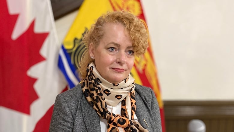 Woman standing in front of Canada and New Brunswick flags