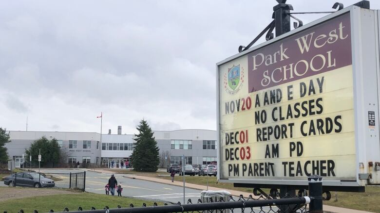 A school sign is shown in front of a school building.