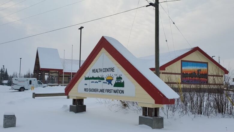 An external shot of the Red Sucker Lake First Nation nursing station, a white building with red trim. An ambulance is parked near the entrance. 