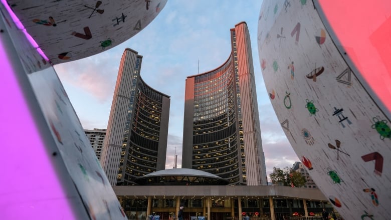 Toronto city hall building, as seen through letters of the TORONTO sign in Nathan Phillips Square.