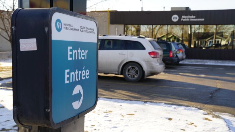 Cars are parked in a parking lot behind a sign that says 