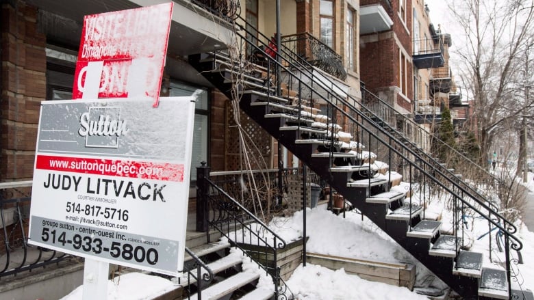 A for sale sign is seen in front of a Montreal home with snow on the sign, on March 17, 2015.