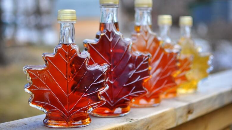 Bright red maple syrup in maple leaf-shaped bottles