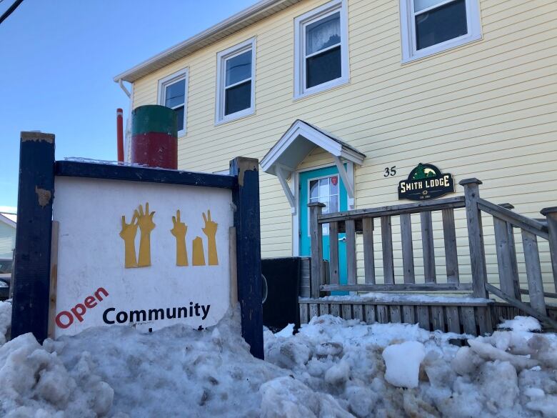 A sign almost buried in snow reads 