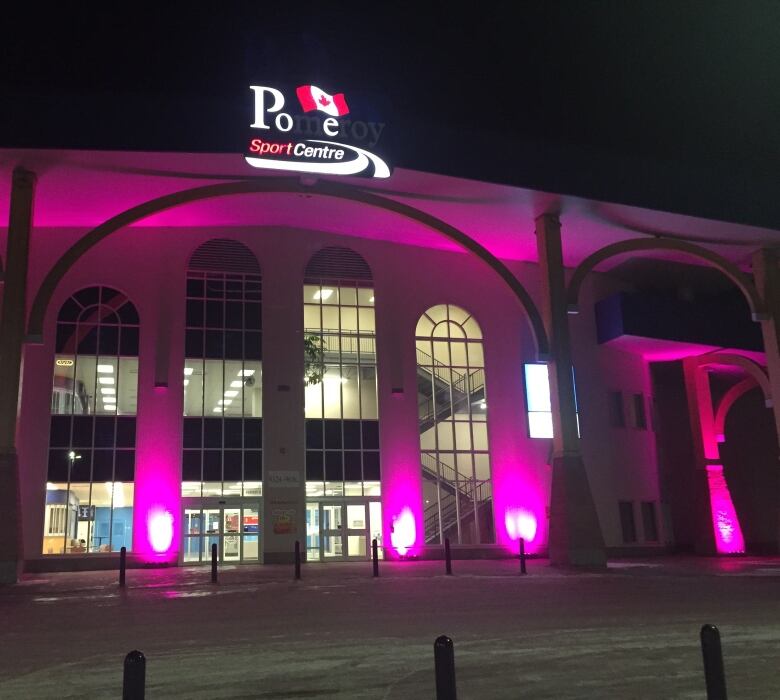 A community centre is lit purple.