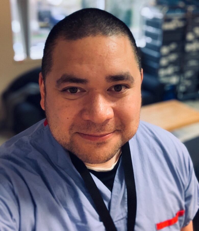 A man wearing blue surgical garb looking up at the camera.