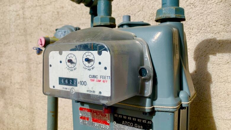 A grey utility meter is shown on the side of a house.