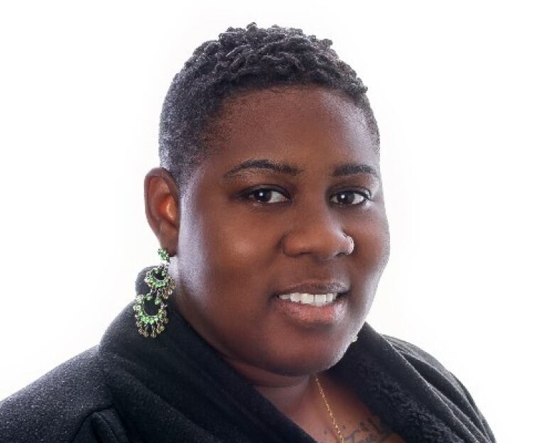 A photo of a woman wearing earrings and a black top.