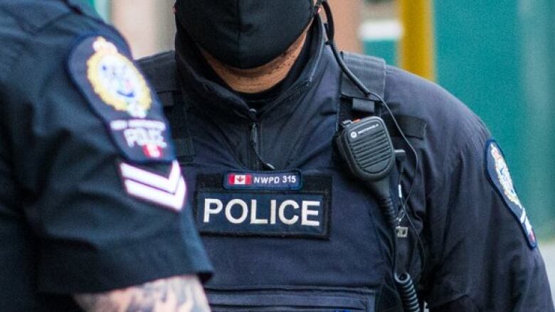 The dark blue uniforms of two police officers are pictured.