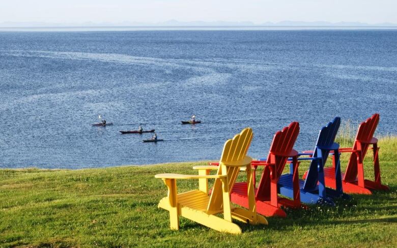 Four colourful chairs overlook the Atlantic Ocean.