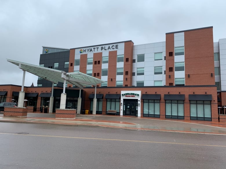 A large, multi-storey brick and metal building with a car port and sign, Hyatt Place, across the top.