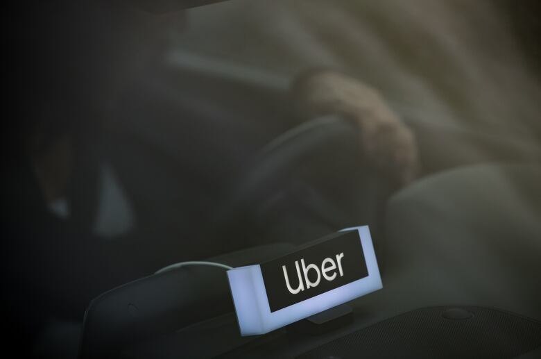 An Uber patch is seen in a vehicle.