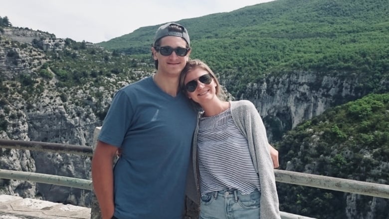 Andrew and Nicole pose for a picture in front of a scenic area. 