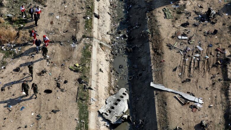 People are seen near the wreckage of a downed plane.