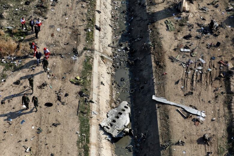 People are seen near the wreckage of a downed plane.