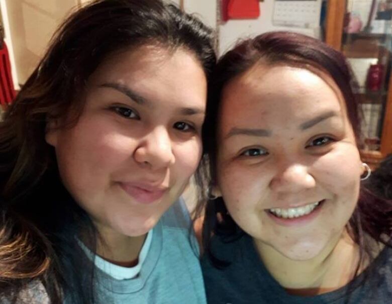 Two women smile and pose together for a photo.