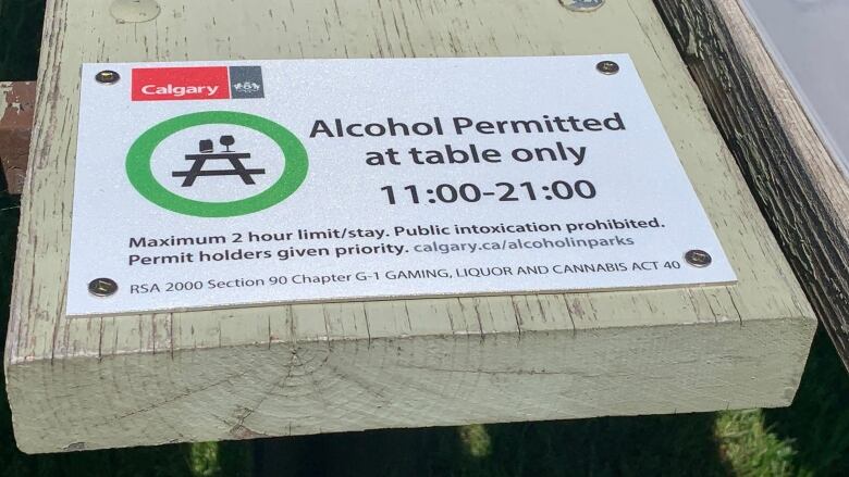 A sign that says 'alcohol permitted at table only 11:00 to 21:00'.