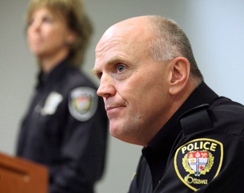 A police chief listens during a news conference.