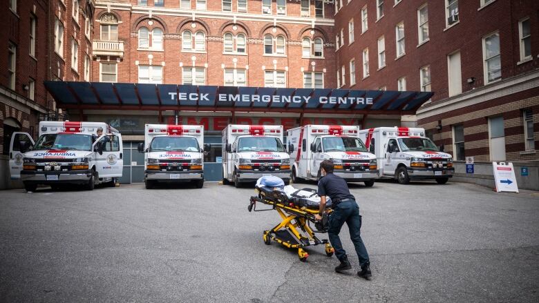 A paramedic rushes a gurney into a hospital.