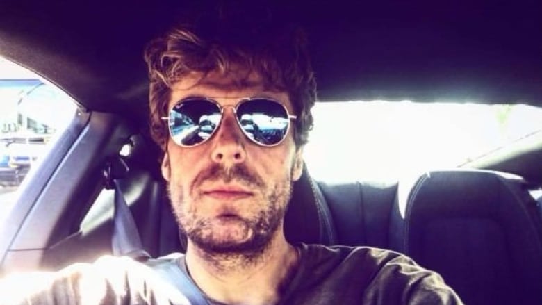 A man wearing sunglasses in a car.