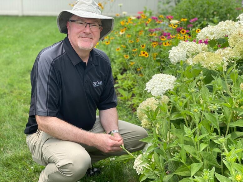 Professor is pictured in front of some plants.