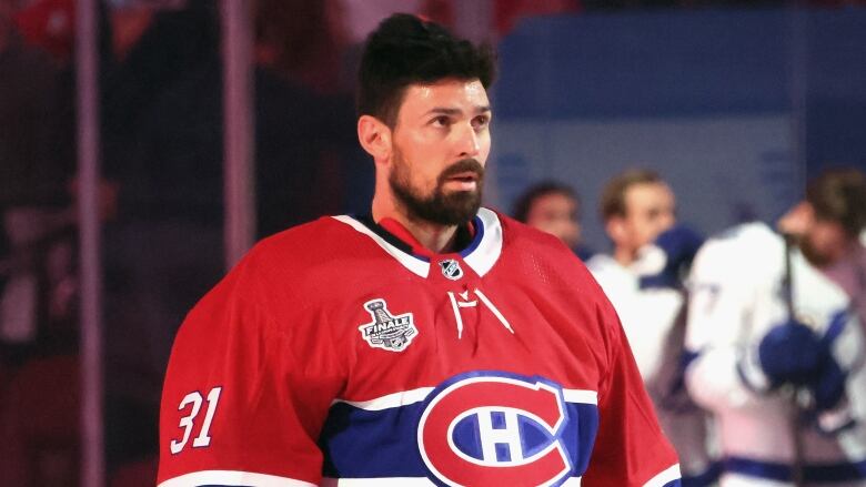 Montreal Canadiens goaltender stands on the ice in uniform without a helmet on. 