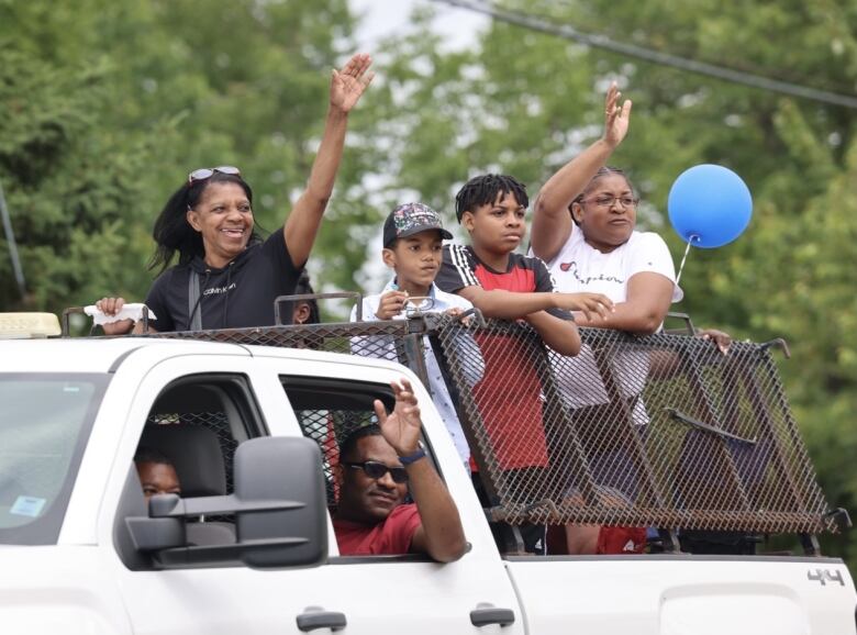 Several people standing in the bed of a truck