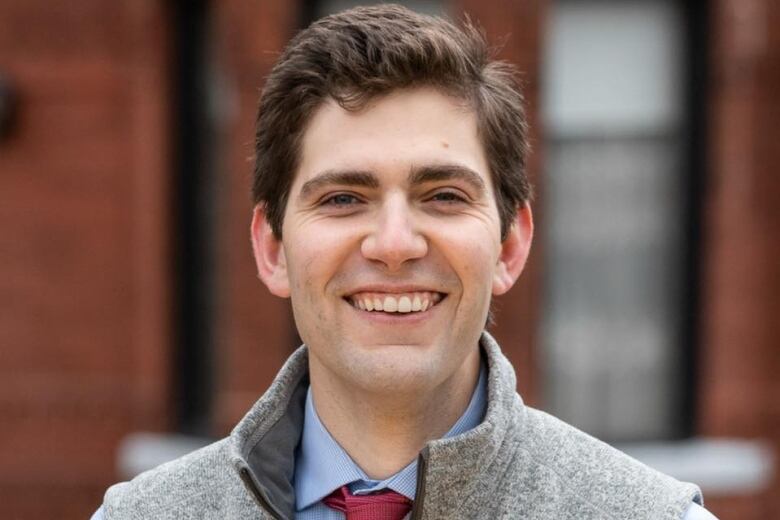 Man standing outside looking at camera smiling.