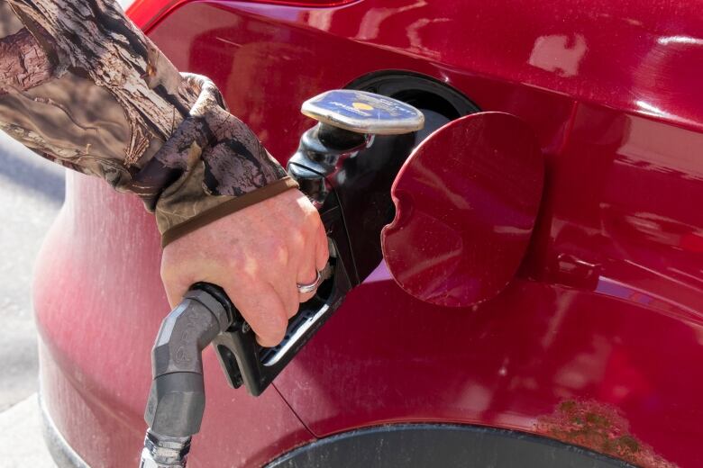 A man pumping gas.