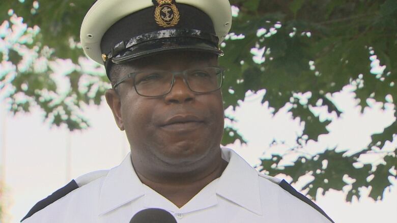 A Black man wearing glasses and a white hat