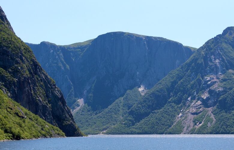 Large mountains stand above a shimmering lake.