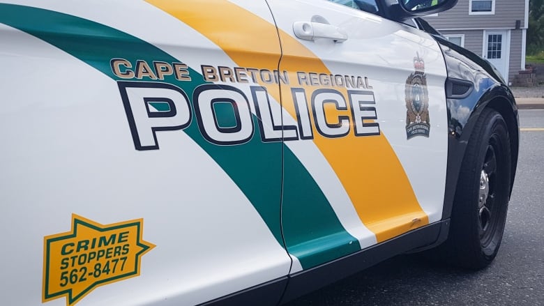 Close-up of the side of a black and white police car with a green and yellow logo saying Cape Breton Regional Police.