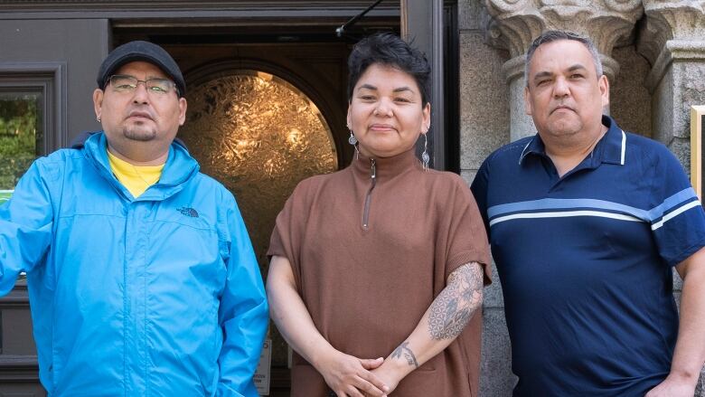 Three people standing in front of court house