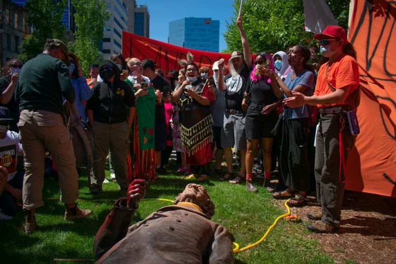 People gathered around a statue on the ground.