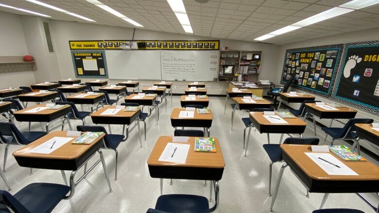 A number of desks sit in an empty classroom