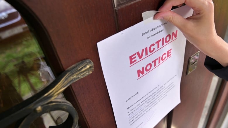 An eviction notice is pasted to a doorway.