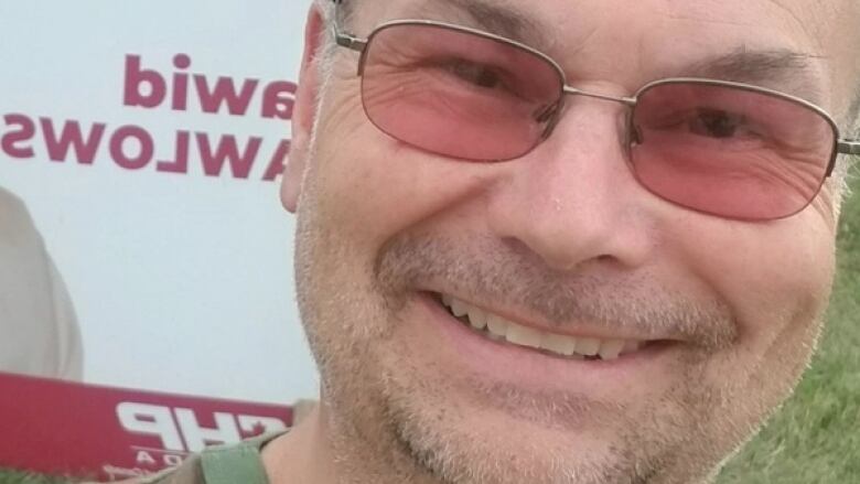 A close-up of a smiling man's face.